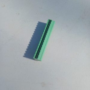 A green Header Terminal Blocks 16 Position piece with black studs is placed on a light surface.