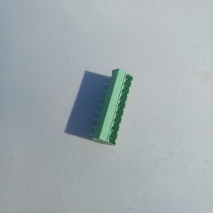 Header Terminal Blocks 9 Position in green plastic with multiple pins on a light grey surface.