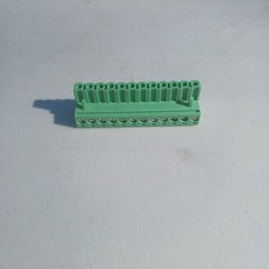 Pluggable Terminal Blocks 12 Position in green plastic with multiple ports, on a light surface in sunlight.