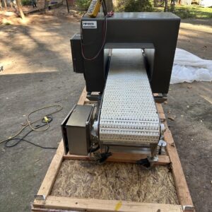 Fortress Belt Stop Conveyor L13899 on a wooden pallet outdoors, with a multimeter resting on top.
