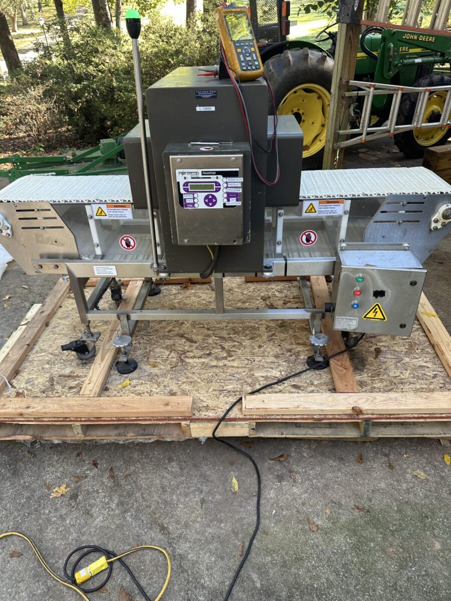 Fortress Belt Stop Conveyor L13899 on a wooden pallet, with control panel and electronic device on top.