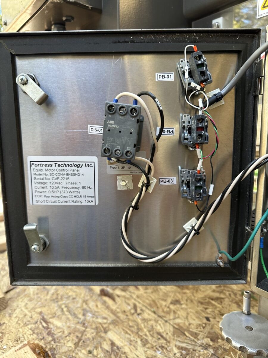 Metal control panel with labeled switches, wiring, and a Fortress Belt Stop Conveyor L13899 info label inside.